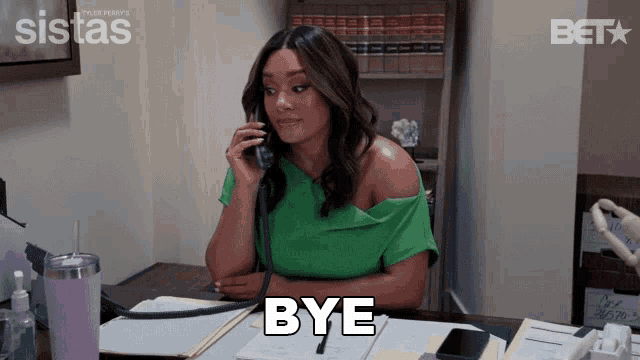 a woman in a green shirt is sitting at a desk talking on a phone and the word bye is above her