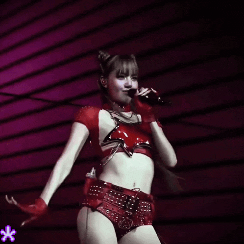 a woman in a red crop top and shorts is dancing on stage
