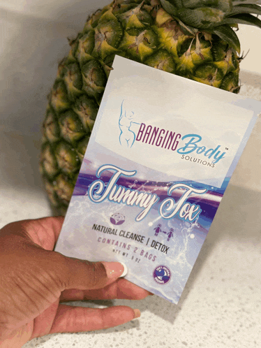 a woman holds a bag of banging body solutions tummy detox