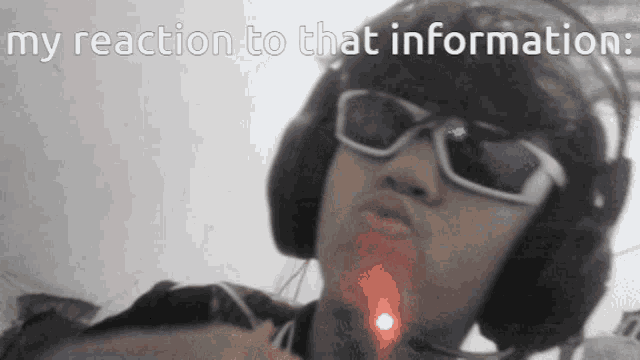 a person wearing headphones and sunglasses with the words " my reaction to that information " on the bottom