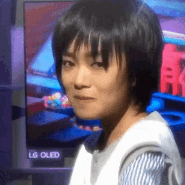 a woman is standing in front of a lg oled television .
