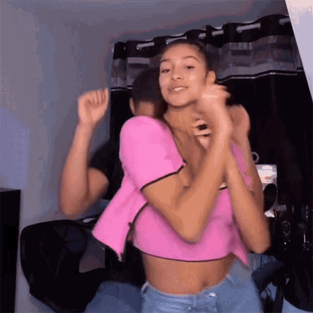 a man in a pink shirt is carrying a woman in a pink top