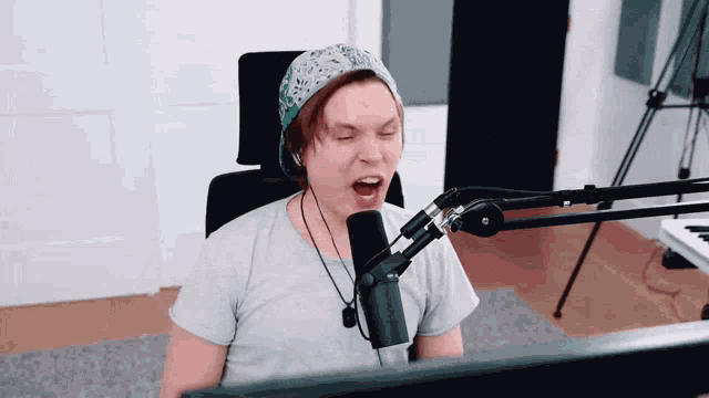 a person singing into a microphone while wearing headphones