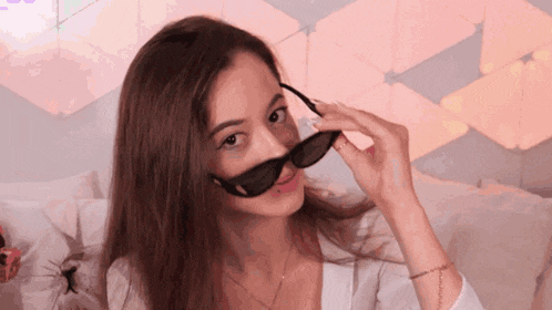 a woman is wearing sunglasses and making a face