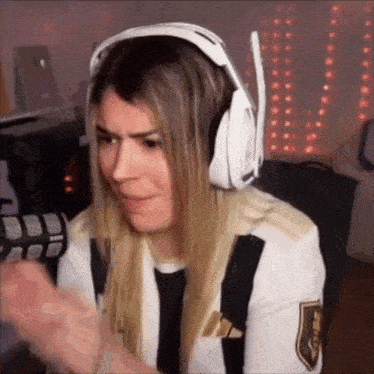 a woman wearing headphones and a black and white striped shirt is making a funny face .