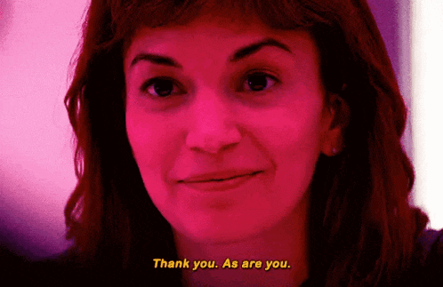 a woman in a pink light is saying thank you as are you