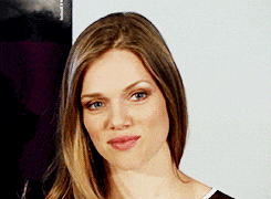 a close up of a woman 's face with a poster in the background that says ' a '