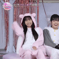 two girls are sitting next to each other and one of them is wearing a pink hoodie