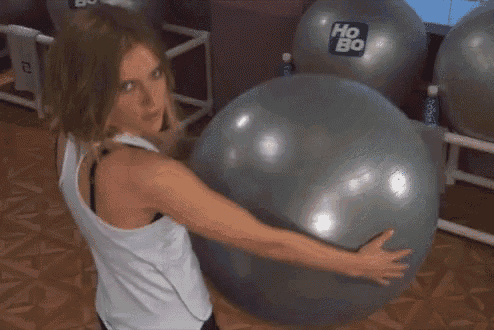 a woman is hugging a gray exercise ball with the word ho bo on it