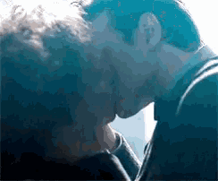 a man and a woman are kissing each other in a dark room .