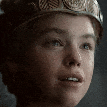 a close up of a woman 's face wearing a crown and smiling .