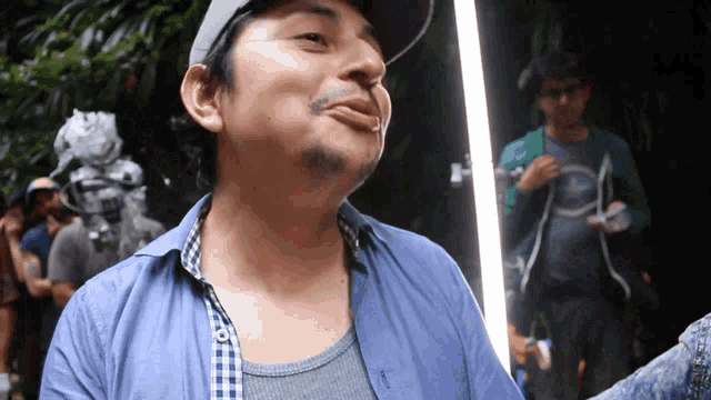 a man wearing a hat and a blue shirt has a beard