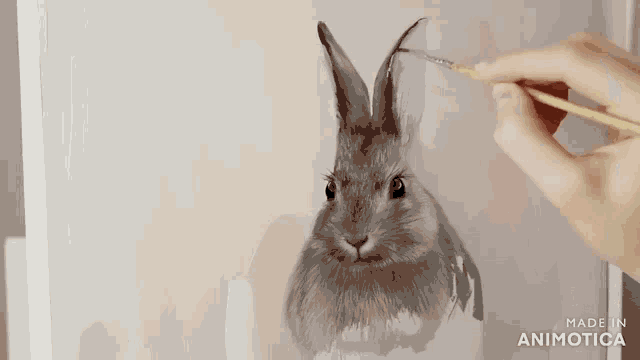 a person is painting a rabbit with a brush and the words made in animatica are visible in the corner