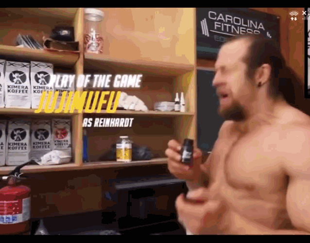 a shirtless man is standing in front of a shelf with kimera coffee boxes on it