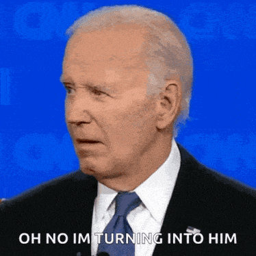 a man in a suit and tie is standing in front of a microphone and says `` oh no im turning into him '' .