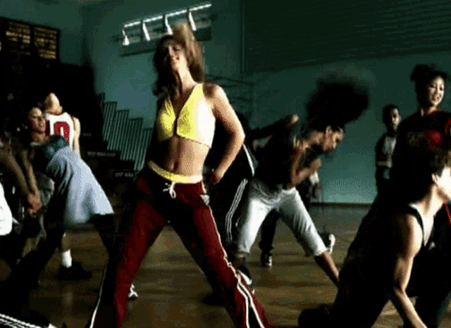 a group of people are dancing in a gym and one of them has the number 10 on his jersey