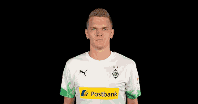 a man wearing a postbank shirt holds his hands up