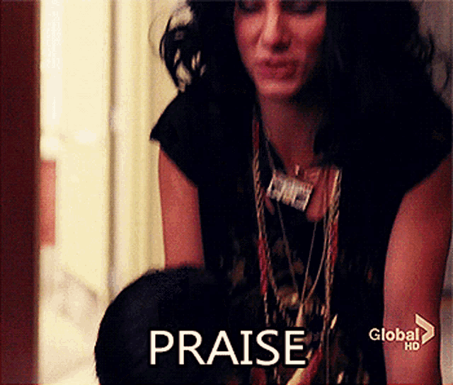 a woman sitting in front of a window with the word praise written on the screen