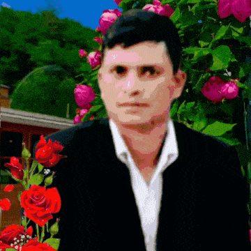 a man in a suit and white shirt stands in front of red roses
