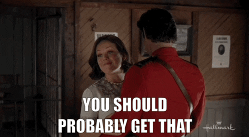 a man in a red uniform talks to a woman in a hallmark movie