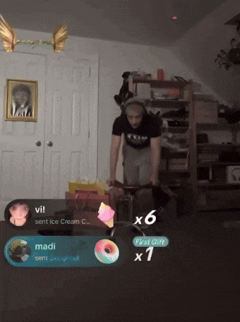 a man in a black shirt is standing in a room with a picture on the wall