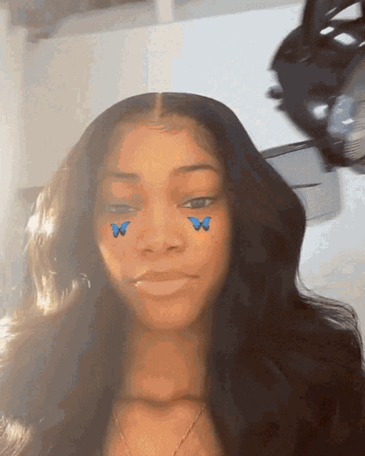 a girl with blue butterflies on her face looks at the camera
