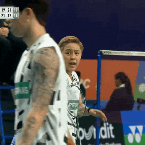 a man and a woman are playing a game of badminton and the woman is wearing a shirt that says petra