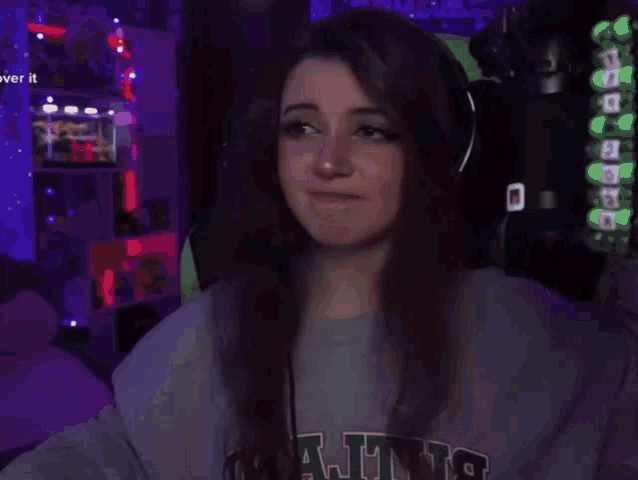 a woman is wearing headphones and making a fist gesture