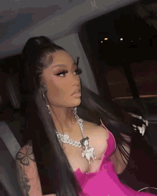 a woman wearing a pink dress and a necklace with a horse on it