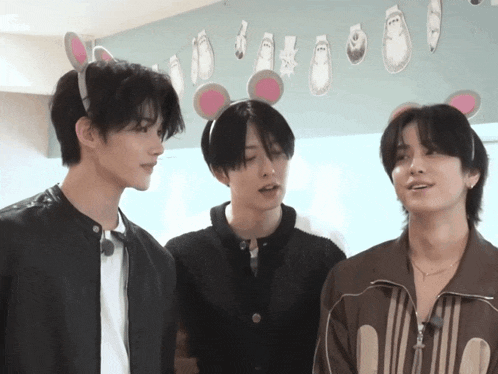 three young men wearing bunny ears are standing together