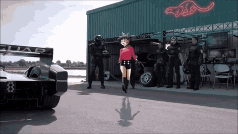 a girl in a red shirt is jumping in front of a jaguar race car
