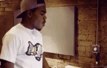 a man wearing a hat and a shirt that says m on it