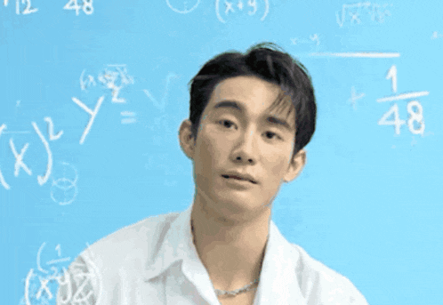 a man is standing in front of a blue board with math equations on it