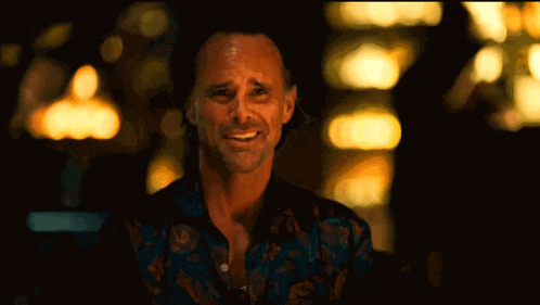 a man in a floral shirt is making a face