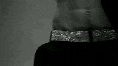 a black and white photo of a glass of water being poured into a glass .