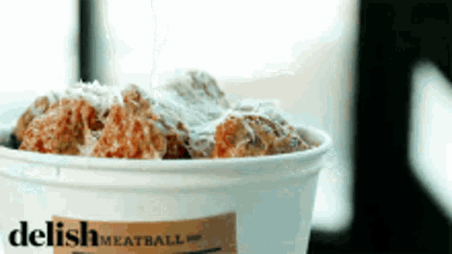 a container of delish meatballs is sitting on a table