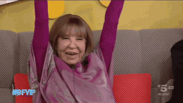 a woman is sitting on a couch with her arms in the air and the words #gfvip on the bottom