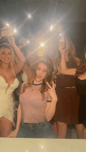 a group of women are taking a picture of themselves in a mirror