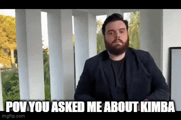 a man with a beard is standing in front of a railing and says " pov you asked me about kimba "