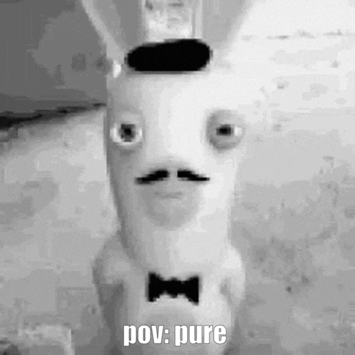 a black and white photo of a stuffed rabbit with a mustache and bow tie .