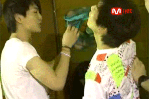 two men are standing next to each other and one of them is wearing a shirt that says mnet on it .