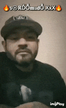 a man with a beard wearing a hat and a black shirt with the words sordomudo xxx