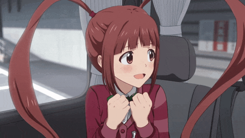 a girl with red hair is sitting in a car and smiling