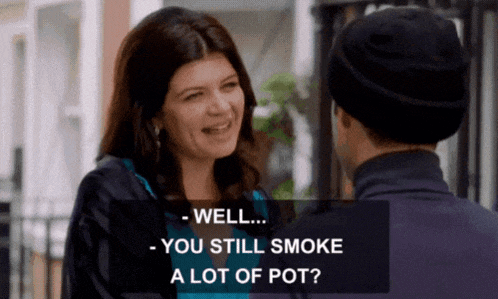 a woman is smiling and talking to a man who is wearing a hat