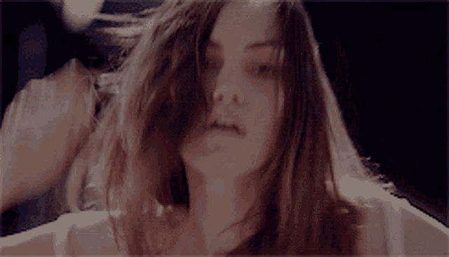 a woman with long hair is looking at the camera