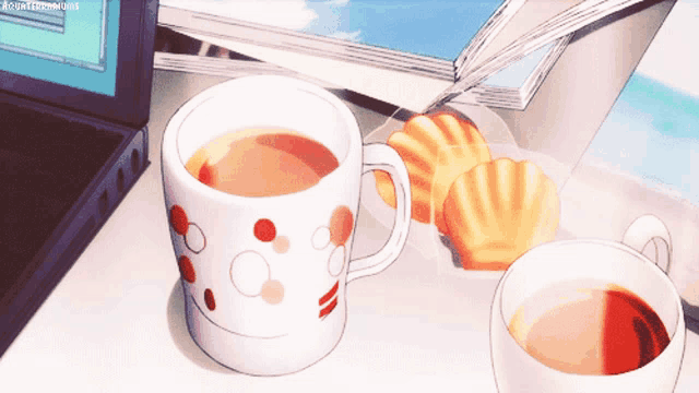 a cup of tea sits on a table next to cookies