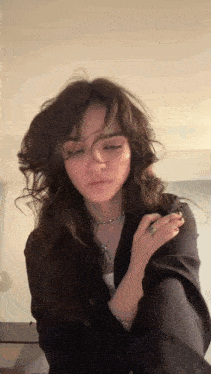 a woman with a nose ring and a necklace is looking at the camera with her eyes closed