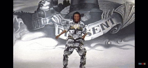 a man is dancing in front of a mural that says present