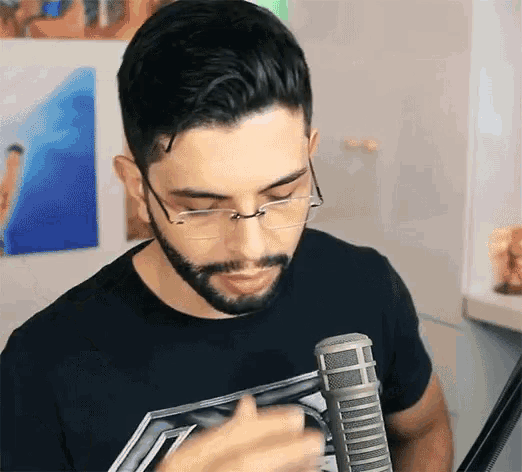 a man with glasses and a beard is holding a microphone