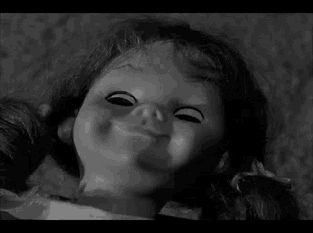 a black and white photo of a creepy doll